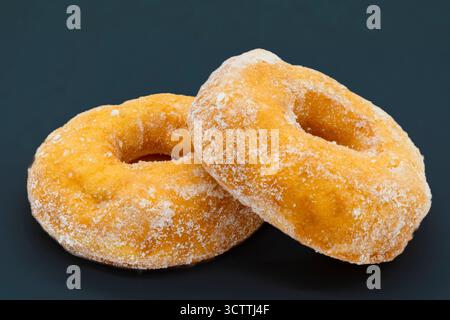 Two sugared crispie deep fried doughnuts one resting on the other. Good image for a cafe menu or delicatessen. Stock Photo