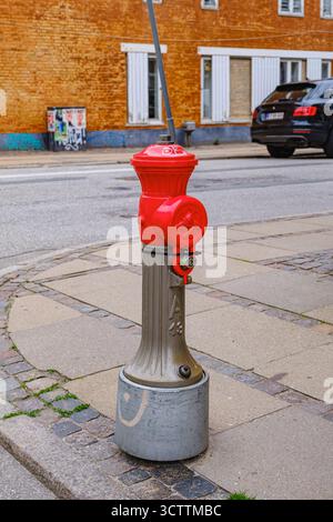 Vintage metal hydrant with bright red top on a sidewalk in the old town part Stock Photo
