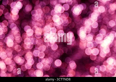 Defocused pink bokeh — dense field of small warm glowing orbs on a dark/black backdrop. A rich, abstract blurred background perfect for wallpapers Stock Photo