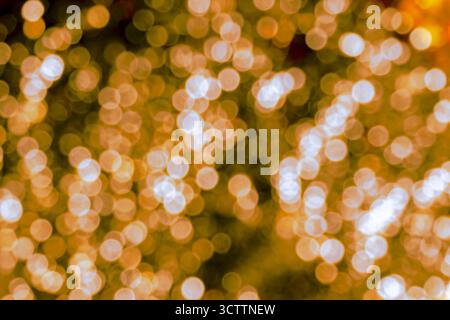 Defocused orange bokeh — dense field of small warm glowing orbs on a dark/black backdrop. A rich, abstract blurred background perfect for wallpapers Stock Photo
