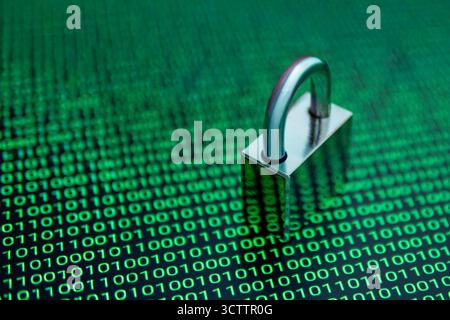 Cybersecurity concept with a padlock over binary code background, symbolizing data protection, encryption, and internet security in the digital world. Stock Photo
