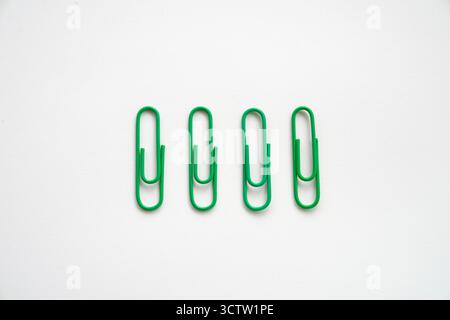 Green Coloured paper clips close-up on a white background Stock Photo