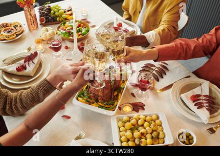 Diverse Group of Adults Toasting Wine Glasses Celebrating Thanksgiving Dinner Stock Photo