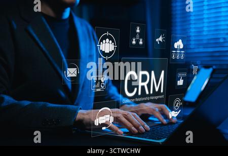 CRM system and customer relationship management technology. Using laptop with digital CRM icons representing customer relationship management, market Stock Photo