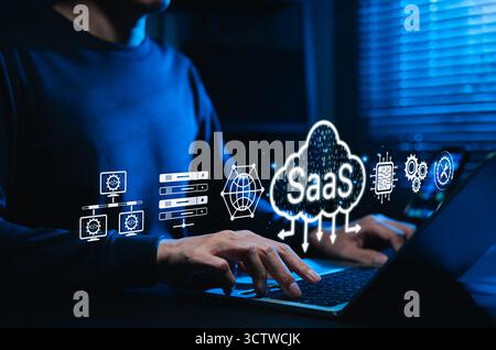 SaaS cloud computing and software service technology. Man using laptop with SaaS and cloud icon, represent Software as a Service, cloud infrastructure Stock Photo