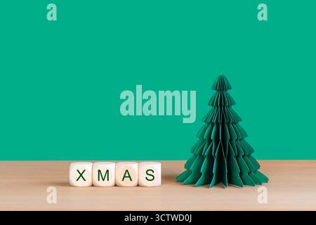 Festive XMAS Dice and Green Paper Christmas Tree on Wooden Tabletop Stock Photo
