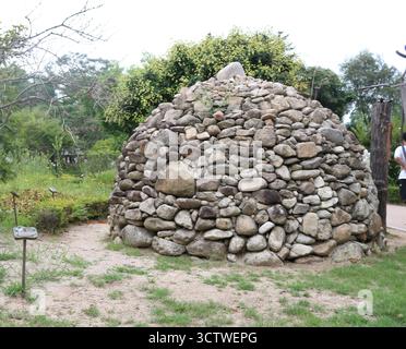 A photograph of a burial mound from a Korean village, c. 1750, constructed from various sizes of grey and brown stones, with a single larger stone resting atop its apex. Korean burial mounds, known as 'tumuli' (??, gobun), have a long and rich history. They range from simple earth mounds to elaborate stone structures. 2025. Stock Photo