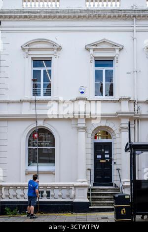 A Man Cleaning Windows In The County Town Of Lewes, East Sussex, UK. Stock Photo