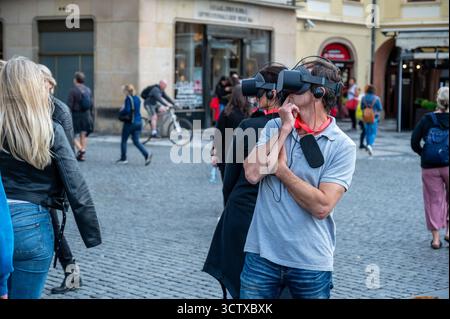 Prague, Czech Republic, August 7, 2023. Tourists wearing VR headsets in the historic center are experiencing a virtual tour of the city. Using technol Stock Photo