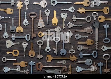 Set of different old keys on wooden background, top view, close up. Safety and security concept. Pattern of many keys Stock Photo