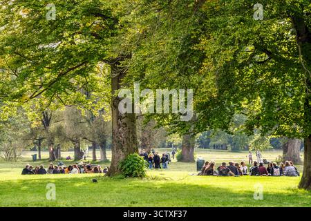 Entspannung im Englischen Garten: mehrere Gruppen von Studierenden, die sich vor Beginn des Semesters zum Kennenlernen im Park treffen, München, Oktober 2025 Deutschland, München, Oktober 2025, Münchner geniessen den sonnigen Herbsttag im Englischen Garten, auch mehrere Gruppen von Studierenden treffen sich vor Beginn des Semesters zum Kennenlernen im Park, das Wintersemester beginnt offiziell in fünf Tagen am 13. Oktober, Lebensfreude, Kennenlernwoche, chöner Herbsttag, Freizeit, Bayern, *** Relaxing in the English Garden several groups of students meeting to get to know each other in the par Stock Photo
