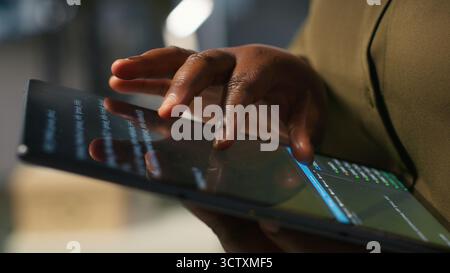 Close up of programmer utilizing AI on tablet to optimize performance and forecast issues. System administrator in office training machine learning models using device, camera A Stock Photo