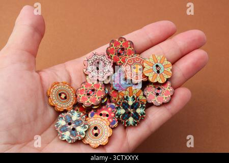 Hand holding wooden buttons with mandalas Stock Photo
