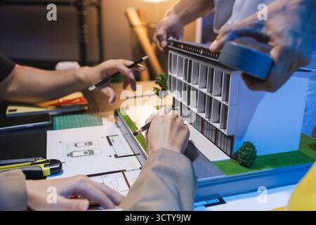 A group of engineers and architects collaborate on a construction project, discussing ideas and sharing technical plans to design innovative modern bu Stock Photo