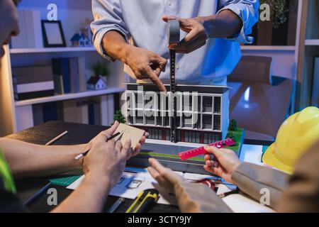A group of engineers and architects collaborate on a construction project, discussing ideas and sharing technical plans to design innovative modern bu Stock Photo