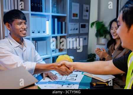 A group of engineers and architects collaborate on a construction project, discussing ideas and sharing technical plans to design innovative modern bu Stock Photo