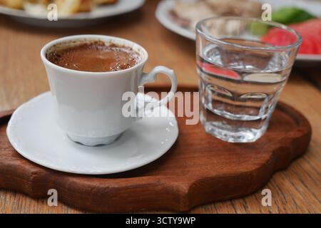 turkish coffee and clear water served on wooden tray in cafe Stock Photo