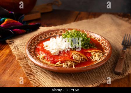 Entomatadas. Also known as Enjitomatadas, a typical dish of Mexican cuisine prepared with corn tortilla, tomato sauce and stuffed with shredded chicke Stock Photo