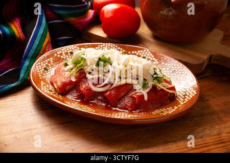 Entomatadas. Also known as Enjitomatadas, a typical dish of Mexican cuisine prepared with corn tortilla, tomato sauce and stuffed with shredded chicke Stock Photo