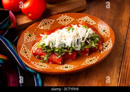 Entomatadas. Also known as Enjitomatadas, a typical dish of Mexican cuisine prepared with corn tortilla, tomato sauce and stuffed with shredded chicke Stock Photo