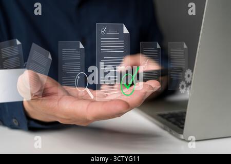 Businessman using laptop with digital documents, online verification checkmark, and data management system concept, representing document approval, au Stock Photo
