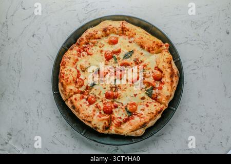 Pomodoro Tomato Sauce, Mozzarella, Basil, Sweet Cherry Tomatoes, Oregano, and Olive Oil Pizza Stock Photo