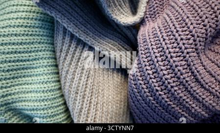 Background is filled with knitted fabric of gray, turquoise, purple colors. Fabrics of different colors are randomly arranged. Fabric has folds. Diffe Stock Photo
