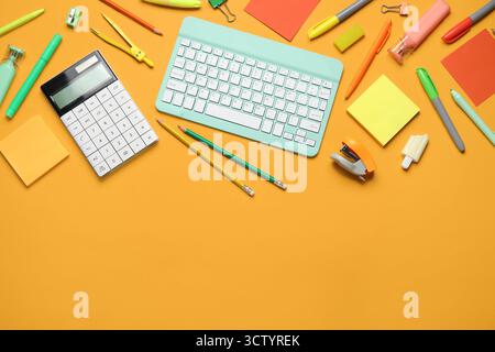 Composition with modern computer keyboard and different stationery on orange background Stock Photo