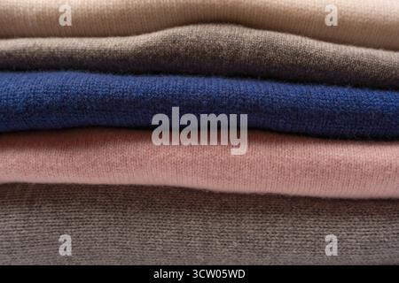 A group of warm sweaters isolated on a white background. Stack of folded sweaters on white background. Stock Photo