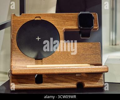 This modern and functional wooden charging station is designed to keep your essential tech organized and powered. Featuring a built-in wireless chargi Stock Photo