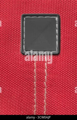 Blank rubber patch stitched on red waterproof fabric background Stock Photo