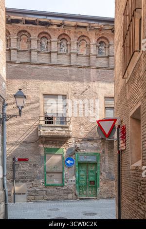Narrow Street Architecture Detail in Historic Spanish Town, Mudéjar Brick Arcades, Rustic Green Door, Antique Lamp, Medieval Alley, Northern Spain Stock Photo