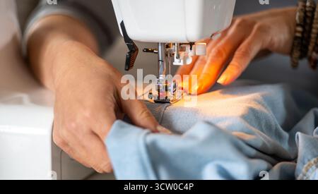 Woman's Hands Sewing On A Machine In Close-Up Stock Photo