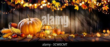 Thanksgiving - Pumpkins And Corncobs On Wooden Table With Rustic Garland And Defocused Abstract Lights Stock Photo