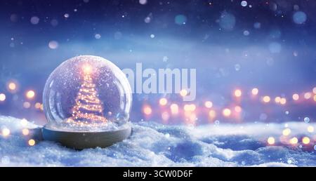 Christmas Tree In Snowglobe On Snow In Night With Shiny Star And In Winter Background - Festive Bokeh Lights Stock Photo