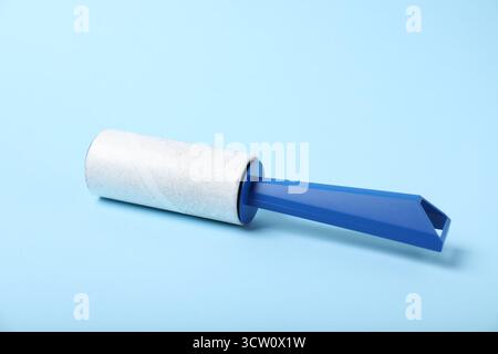 One lint roller on light blue background, closeup Stock Photo