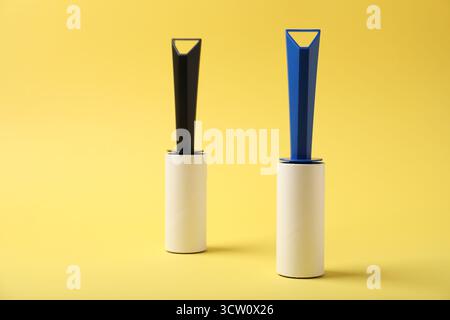 Two sticky lint rollers on yellow background Stock Photo