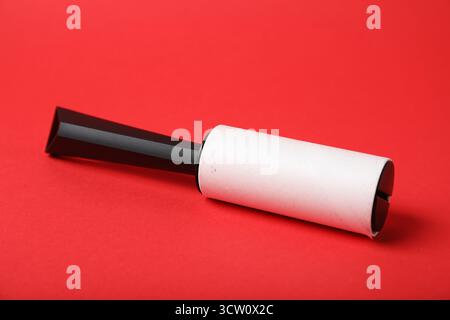 One lint roller on red background, closeup Stock Photo