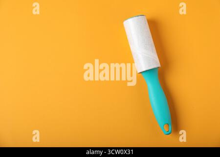 One lint roller on orange background, top view. Space for text Stock Photo