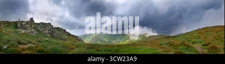 Thunderstorm dark clouds over mountain landscape panorama. Mount Gutyn Tomnatyk and glacial lake Brebenekul from the slopes of Mount Brebeneskul Stock Photo