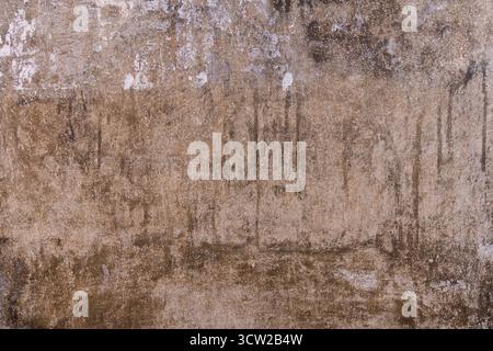 Aged, weathered concrete wall with rough, gritty texture, streaks, and natural color variations, showing years of exposure and rugged character. Stock Photo