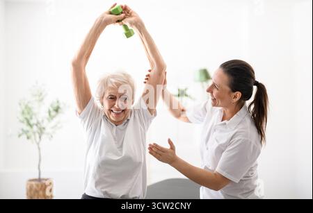 A physiotherapist helping senior woman in clinic. Elderly woman undergoing physiotherapy treatment for injury Stock Photo