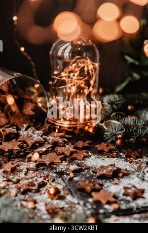 Traditional Christmas gingerbread cookies on a dark background with bokeh lights. Vertical photo, Holiday Season activity. Stock Photo