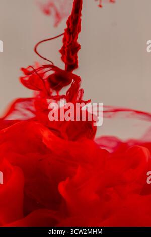 Vivid red ink swirling in water. Stock Photo