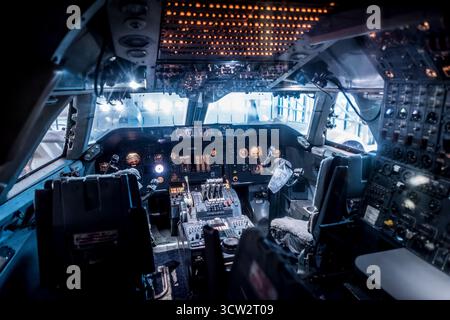 Cockpit Of Boeing 747 Airplane Smithsonian National Air And Space Museum Washington DC | WASHINGTON D.C., United States — The illuminated flight deck of a Boeing 747 fills this cockpit view inside the National Air and Space Museum. Known as the Jumbo Jet, the 747 first flew in 1969 and became the aircraft that made mass long-haul air travel possible, its four-engine, wide-body design carrying passengers and cargo across the world for more than five decades. Stock Photo