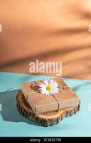 Craft gift box decorated with chamomile flower. Stock Photo