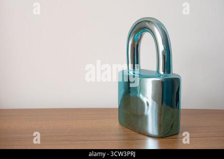 A sharp, stylized shot captures a bright metal padlock securely resting on a smooth brown surface, which is isolated against a clean white background Stock Photo