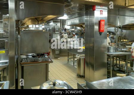 Atlantic Ocean - Oct 1, 2025 A large, bustling professional kitchen with multiple chefs working among stainless steel equipment, commercial appliances Stock Photo
