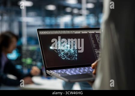 Close up of data center developer using laptop, working on databases supporting AI applications. IT professional uses notebook in server hub, doing algorithms improvements with artificial intelligence Stock Photo