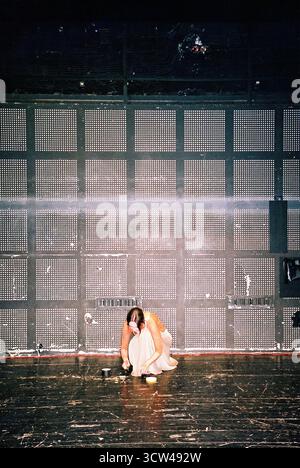 Ballerina checks the floor before rehearsal, preparing to dance, captured in analog style with soft natural light and candid focus. Stock Photo
